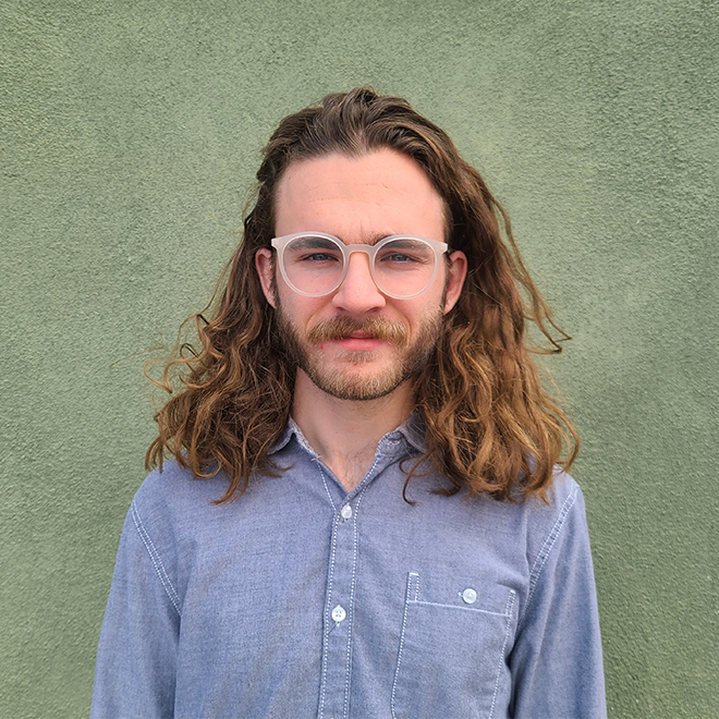 A person wearing clear glasses and a button-up shirt