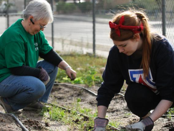 A UA student and a volunteer supervisor volunteering near campus 