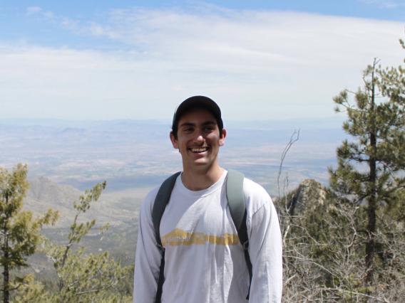 Aaron Nach standing in front of trees and mountains