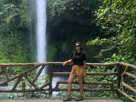 Mackenzie Moore standing in front of a waterfall