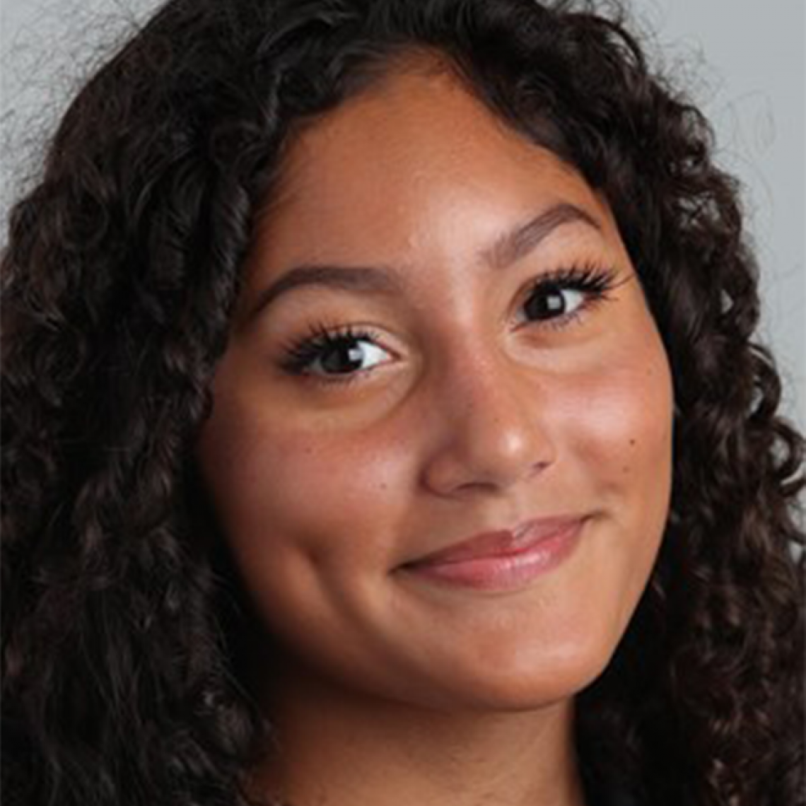 A woman with curly dark hair smiling