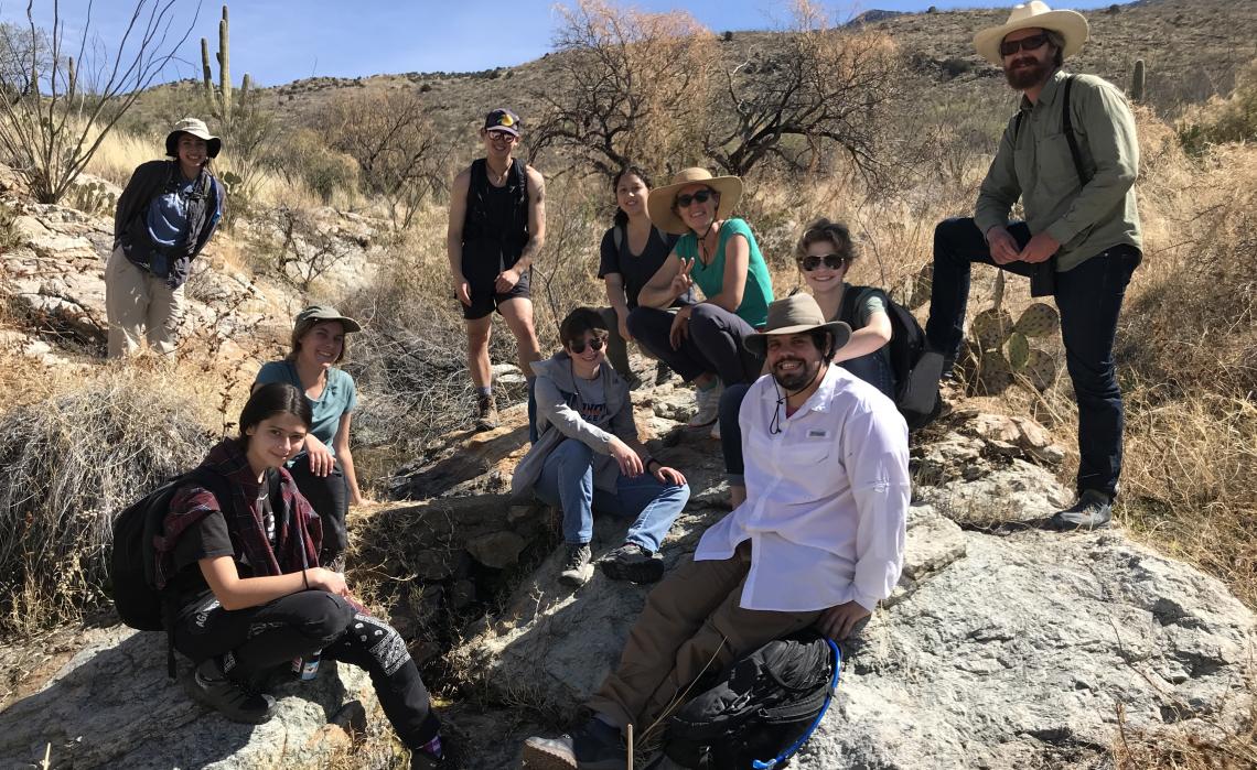 Earth Grant and UC3 students and Sky Islands Alliance staff pose by Rock Spring in Saguaro National Park East.