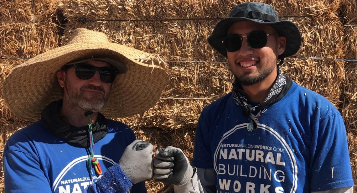 Natural Building Works founder Ray Clamons fist bumping and standing with Earth Grant student Daniel Vega