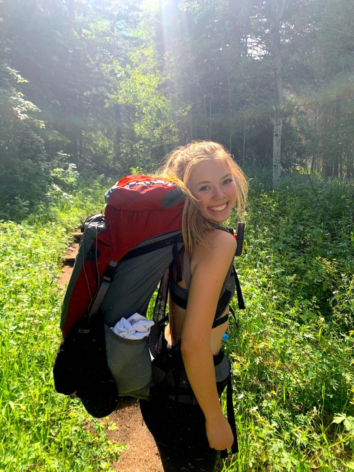 Jeri Wilcox with a backpacking pack on in a forest