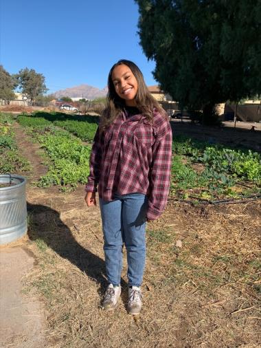 Ani Melicar standing in the IRC New Roots garden.