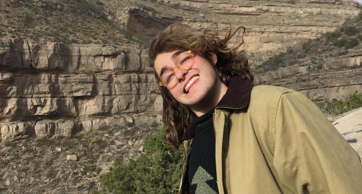 Burke Wood smiling in front of large mountain rock