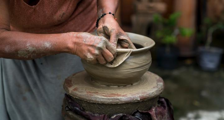 person sculpting a bowl out of clay